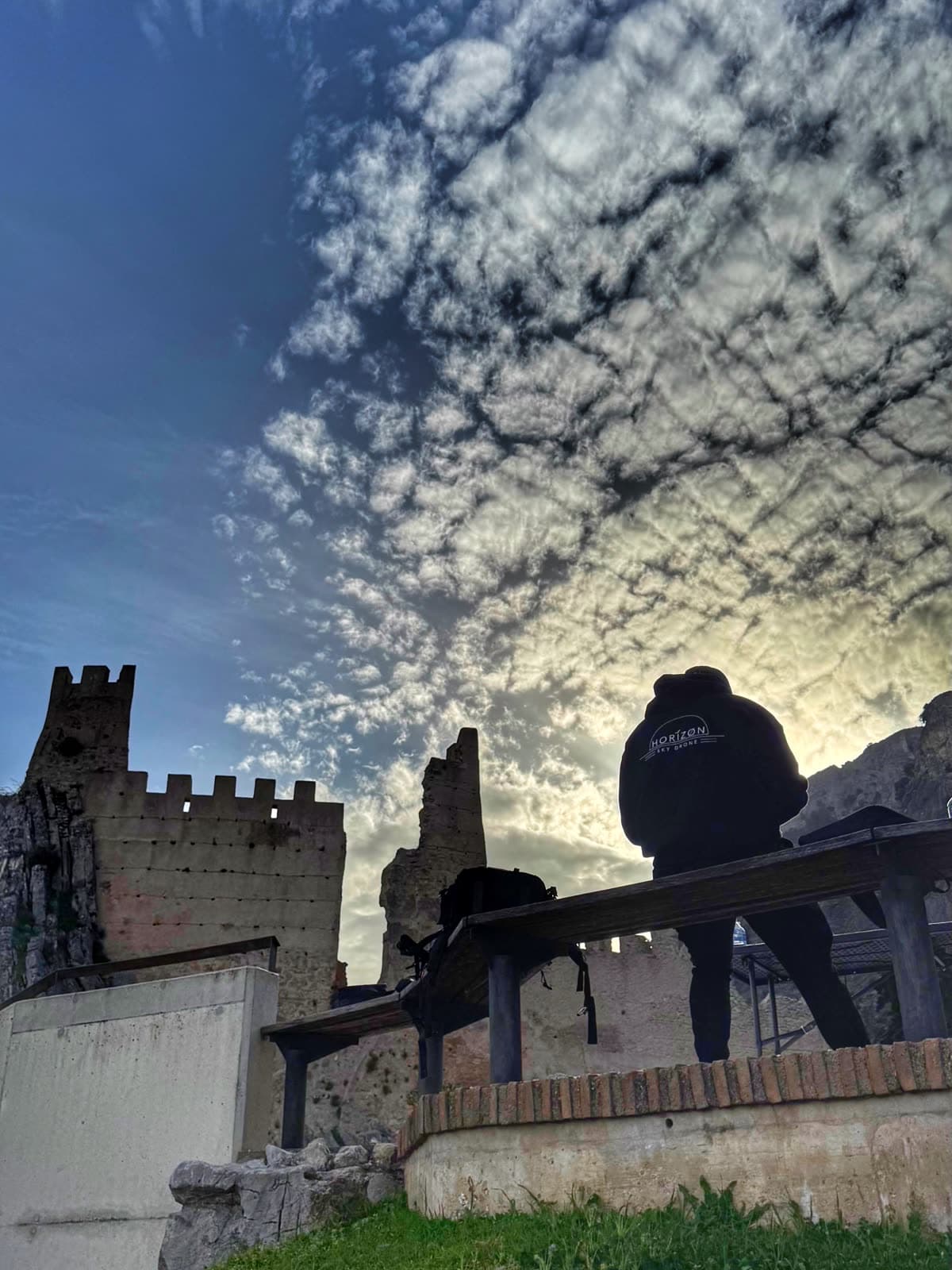 Silueta de un piloto de Horizon Sky Drone junto a un castillo al atardecer